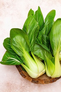 Fresh bok choy, close-up, in a wooden bowl, top view, no people