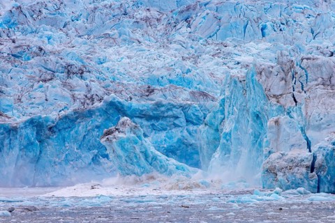 Ice chunk breaking from edge of calving Kongsbreen, marine-terminating glacier debouching into