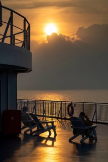 Travellers in deckchairs at sunset, Finland ferry Helsinki to Travemünde, Baltic Sea