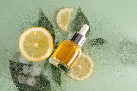 A vibrant skincare scene with a cosmetic of citrus serum placed alongside fresh lemon slices and a