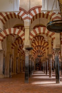 Seemingly endless row of Moorish arches with hanging lamps in the cathedral mosque of Córdoba