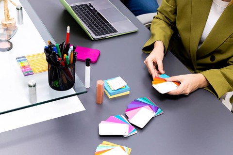 A professional image consultant arranges an array of colorful swatches on a table. Tools like