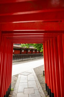 Majestic view through the vibrant red torii passage at Kitano Tenmangu Shrine in Kyoto, Japan,