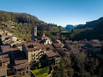 A picturesque aerial view captures a charming village nestled among lush hills in Montserrat,