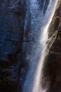 Water from a waterfall splashing between the rocks, illuminated by the sun in Minas Gerais, Minas