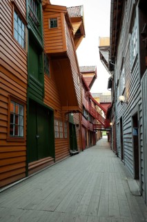 Summer day exploring behind facades in Bryggen Bergen, narrow lanes, colorful wooden buildings,