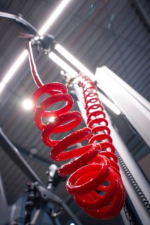 Red spiral cable in front of an illuminated ceiling in a workshop from an unusual angle, Waldbike