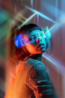 Latin woman engages in a futuristic experience using virtual reality glasses. Surrounded by vibrant