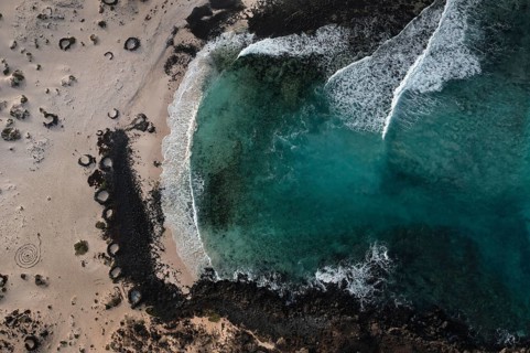 An aerial shot captures the stunning natural beauty of Caleton Blanco Beach in Lanzarote,