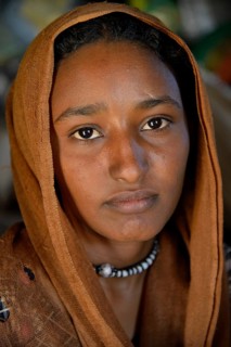 Young girl from a nomadic tribe, wearing headgear, portrait, Bayuda Desert, in Karima, Nubia,