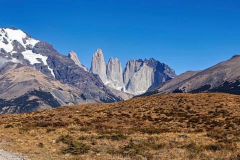 Dramatic rock formations under a blue sky in an arid landscape, The rock towers of Torres del Paine
