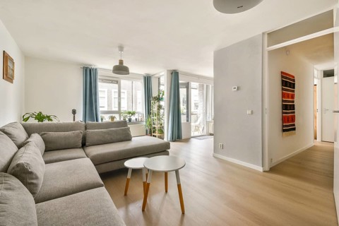 Elegant and modern living room showcasing a spacious gray sectional sofa against a bright backdrop,