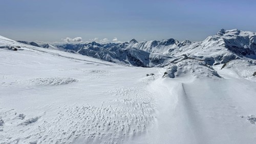 A stunning view of snow blanketed mountains under a clear blue sky, offering a serene winter