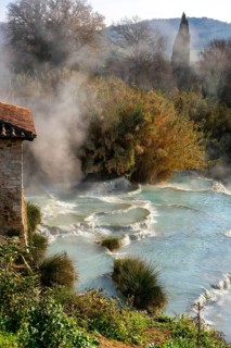 The Saturnia hot springs in Tuscany, Italy, with natural thermal pools emitting steam surrounded by