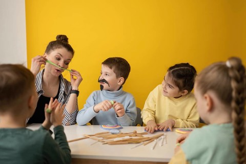 A fun, creative learning session with children engaging in arts and crafts. A teacher and kids