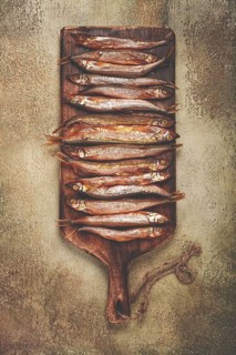 Cold smoked capelin, on a wooden chopping board, no people