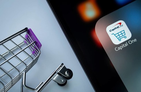 A close up of an iPad screen displaying the Capital One app alongside a mini shopping cart