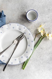Top view of a minimalist breakfast setting featuring an empty plate with blue polka dots, a