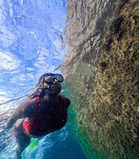 A snorkeler female explores the clear waters of Tindaya Beach's natural pools, showcasing the