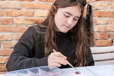 A young artisan engrossed in crafting with vivid Burano and Murano glass in Venice, capturing the