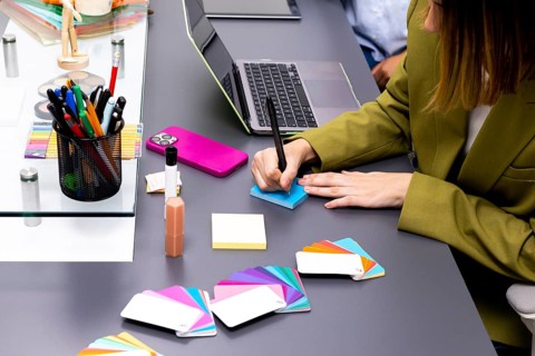 A professional consultant in an office uses color swatches and notes to develop branding strategies