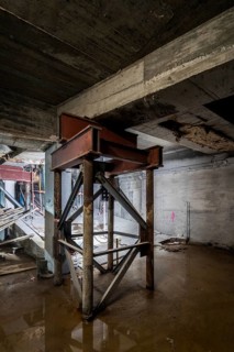 A construction site features exposed metal beams and concrete structures in an industrial setting.