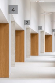 A serene view inside a building featuring minimalist design with white walls and wooden details,