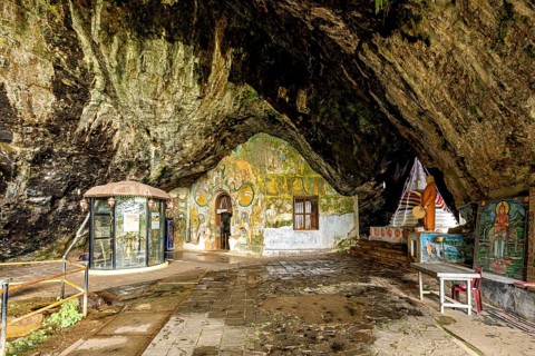 Entrance area of a cave with richly decorated walls and religious expression, The Diva Guhawa cave