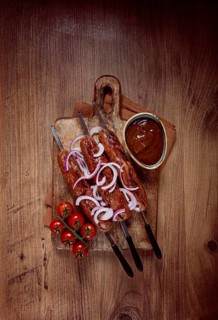 Fried sausages, in English with bacon, for grilling, on a cutting board, top view, no people