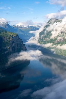 Atmospheric clouds over the fjord in the morning light, view of Geirangerfjord, at Ørnesvingen