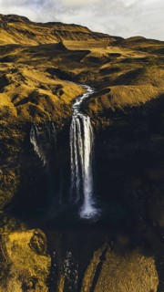 A stunning aerial view of Seljalandsfoss waterfall in Iceland, with water cascading down a high