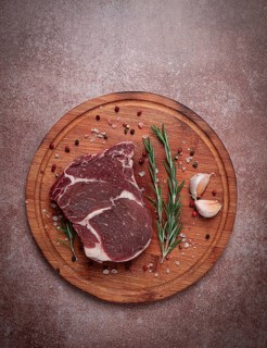 Fresh raw rib eye steak, on a cutting board, top view