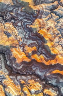 Aerial view of vibrant bentonite formations in Utah, showcasing swirling patterns and rich golden