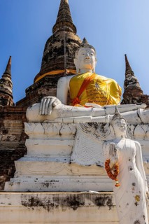 Stone Buddha statue decorated with yellow cloth, historic Buddhist temple complex, Ayutthaya,