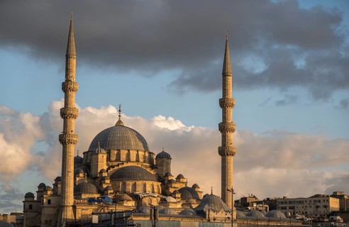 Majestic view of a historical mosque in Istanbul, captured under a glowing sky at sunset. The