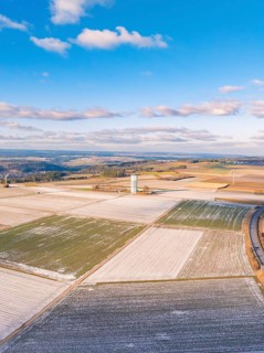 Extensive fields under a blue sky, a tower stands out in the centre, district of Calw, Germany