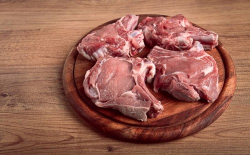 Raw calf meat, meat on the bone, meat for barbecue, cutting board, top view