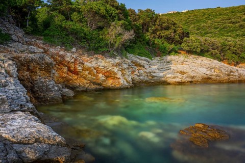 Crystal clear and turquoise water on the beach of Ustrine Bay on a sunny day at sunset on the