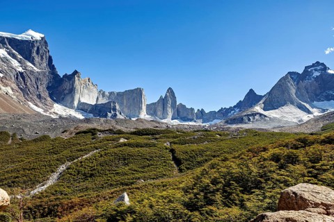 Majestic mountains with glaciers under clear skies and green vegetation, the landscape of Torres