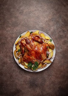 Fried, baked chicken, in the oven, with spices, and rustic potatoes, top view, homemade