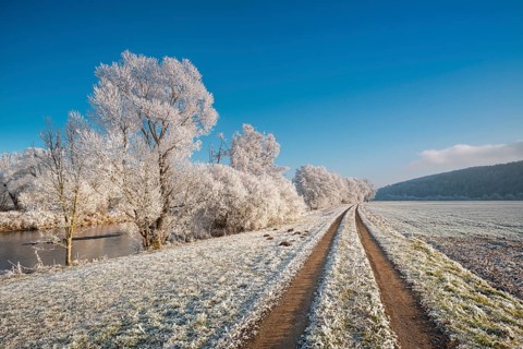 Hiking trail on the river Eder in winter, trees and fields with hoarfrost, near Bad Wildungen,