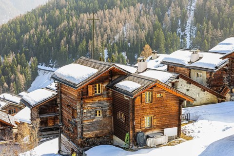 Snow-covered roofs of old farmhouses and Stadel warehouse, historic town center, Grimentz, Val