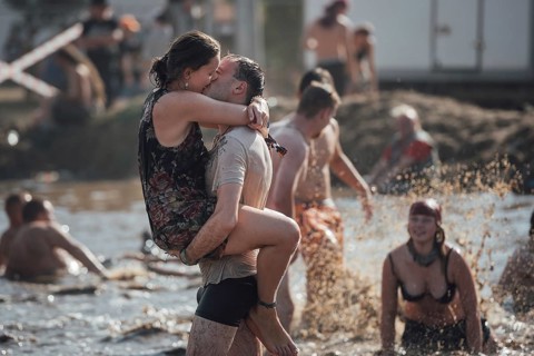 KOSTRZYN NAD ODRA, POLAND - AUGUST 2, 2018: Fans of Pol'and'Rock Festival kissing in the mud pond