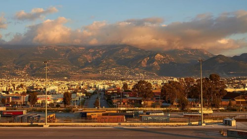 The city is picturesquely situated against a mountain backdrop in the warm evening light, New ferry