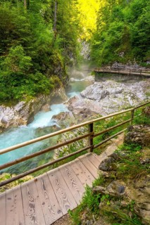 Scenic view of a wooden walkway and turquoise river flowing through the picturesque vintgar gorge,