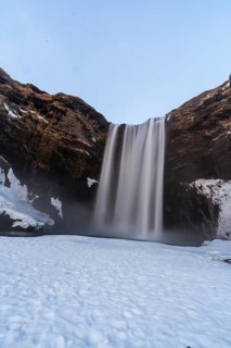 View of frozen Skogafoss waterfall filled with snow in winter in Iceland