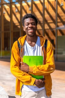 Vertical portrait of a confident and smiling african american student outside the university