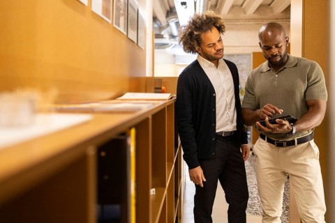 Two professionals collaborate in a modern coworking space in Barcelona, engaging in a discussion