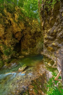 Breathtaking wooden walkway crossing an emerald green river in the stunning vintgar gorge near