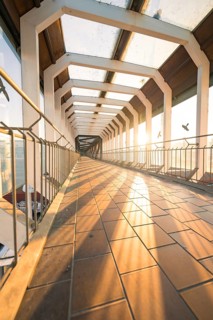 A long glass corridor with incident sunlight creating a warm pattern on the floor, Sindelfingen